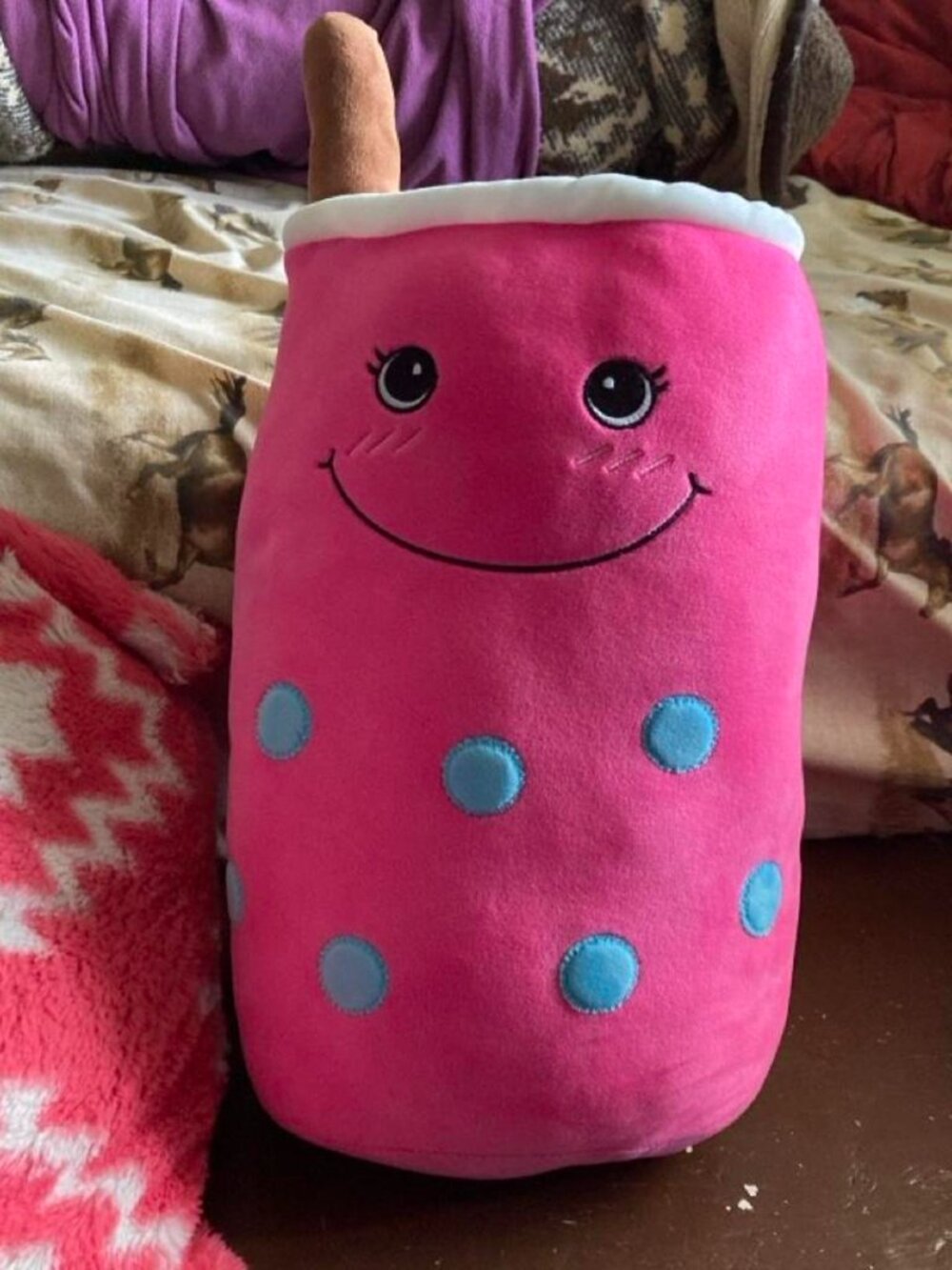 Pink bubble tea plushie with blue polka dots and a smiling face